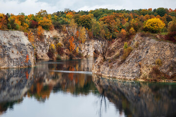 Autumn landscape with lake in the Zakrzówek Quarry, Krakow. Colorful autumn trees on the shore.
