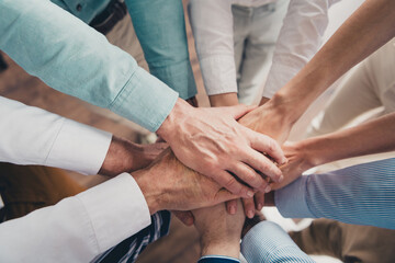 Cropped photo of teamwork people working together hold hands help comfortable modern office loft...