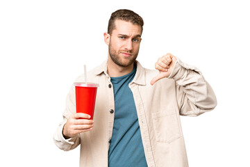 Young handsome blonde man holding soda over isolated chroma key background showing thumb down with negative expression