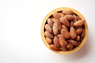 Roasted almonds, sea salt roasted almonds in wooden bowl on white background