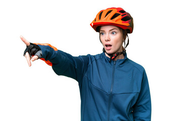 Young cyclist woman over isolated chroma key background pointing away