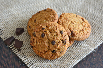 a cookie with chocolate chips on the burlap background top view