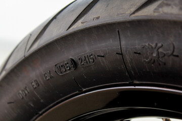Close up shot of a tire showing the tread pattern and manufacturing details