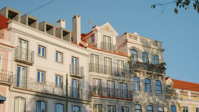 Establishing shot of traditional building in Lisbon Portugal on sunny day. Colorful neoclassical architecture style renovated luxury building for residential expensive apartments in summer or spring