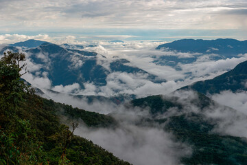 Stunning aerial view captures the andes mountains, with clouds flowing through green valleys between towering peaks