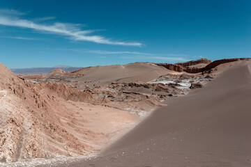 Scenic view of the arid landscape of the moon valley in the atacama desert, chile, featuring brown sand dunes, rocky formations, and a clear blue sky
