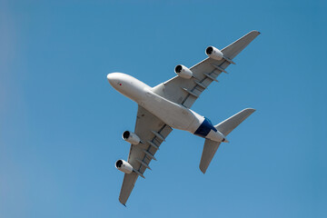 Large passenger jet gracefully maneuvers through the clear blue sky, showcasing the elegance and power of modern aviation