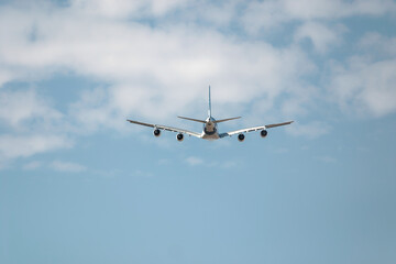 Sleek passenger plane soars through fluffy clouds, symbolizing the excitement of air travel. Blue...