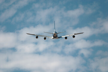 Passenger jet plane soars through a cloudy sky, symbolizing travel and freedom with a stunning backdrop of blue sky and white clouds