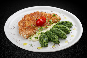 Chicken schnitzel served with sauce, accompanied by broccoli and cheese fritters.