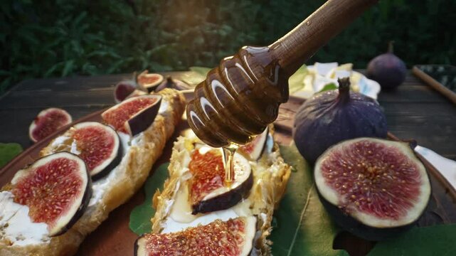 Honey pouring on camembert cheese croissants with fig slices. Brie, healthy juicy organic figs. Appetizer breakfast set. Seasonal fruits.