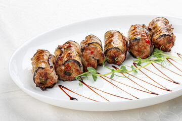 A savory meat roll stuffed with roasted eggplant, creating a flavorful blend of textures and tastes.