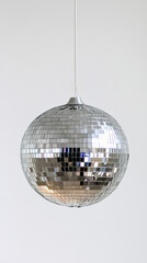 Obraz premium Hanging disco ball with mirrored surface on white background