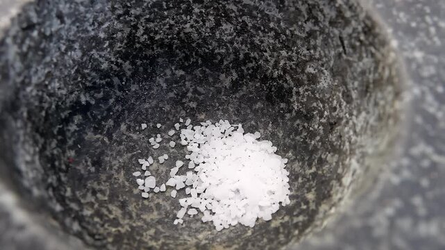 Sea salt is poured into a stone mortar. High quality 4k footage