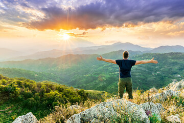 Fototapeta premium happy man watching amazing highland evening sunset, person delight with nature landscape