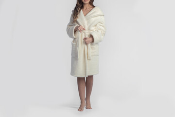 Beautiful young woman in a dressing gown on a white background.