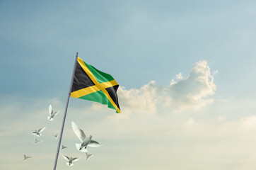 Jamaica flag waving with flying doves in beautiful sky. Jamaica flag for Republic Day and Independence Day.