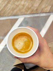 Woman hand holding hot coffee cup. Espresso coffee shot in paper cup