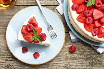 Tasty sponge cake with fresh berries and mint served on wooden table, flat lay