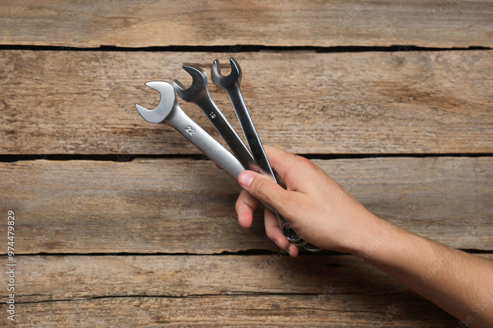 Sticker Auto mechanic with wrenches at wooden table, closeup