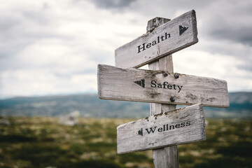 health safety wellness text quote on wooden directional signpost outdoors in nature