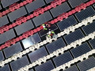 Male workers repair Floating solar panels on water lake. Engineers construct on site Floating solar panels at sun light. clean energy for future living. Industrial Renewable energy of green power.