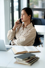 Elder female executive uses a mobile phone to talk at the desk