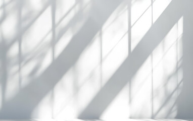 Soft shadow of window frame pattern on a white wall, creating a minimalist and calm atmosphere ideal for creative backgrounds or interior design concepts.