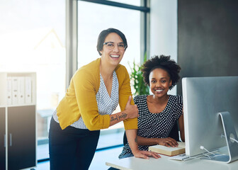 Portrait, manager and graphic designer training on computer for online website, advice or software. Textbook notes, empower and happy women at media agency on desktop for digital training or skills