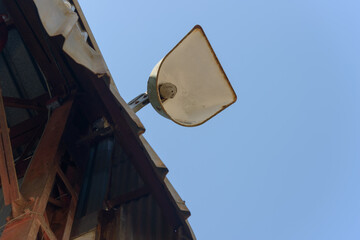 old lamp with insect nest on a blue sky