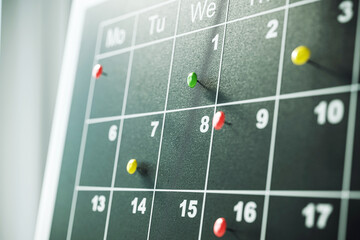 Close-up of a calendar with colorful pins marking important dates. 3D Rendering