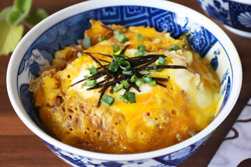 Tamagodon (tamago don, donburi), a Japanese rice bowl topped with soft, simmered eggs cooked in a savory dashi-based sauce, often with onions and served over steamed rice. Delicious vegetarian meal.