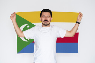 Moustached man holding Comoros flag, independence or celebration day idea, campaigning concept