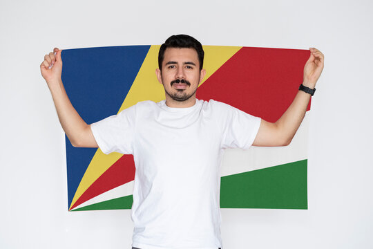 Moustached man holding Seychelles flag, independence or celebration day idea, campaigning concept