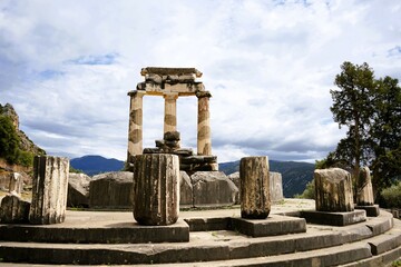 Fototapeta premium Stone remains of a tholos, a sacred circular building with columns in the sanctuary of Athena Pronaia in Delphi in Greece