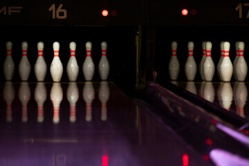 Artistic bowling photo, wallpaper. Bowling lane with strong colourful lighting. Close up of bowling pins in a modern newly built alley.