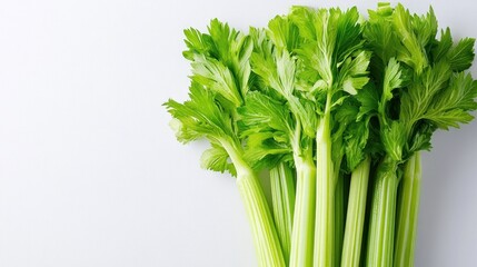 Fresh green celery stalks arranged on a light background, ideal for cooking or salads.