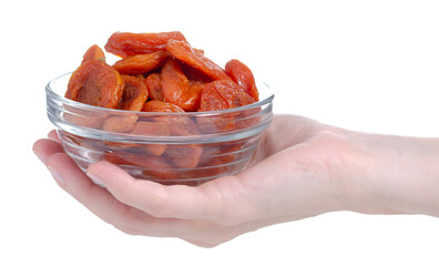 Glass bowl with dry apricots in female hand on white background isolation