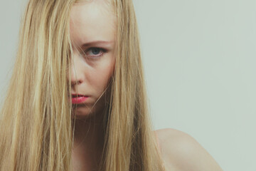 Sad girl covers her face with long hair