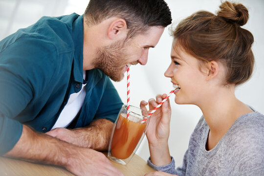 Love, milkshake and drink with couple on date for romance, bonding and happiness. Smoothie, coffee shop and care with man and woman sharing at cafe restaurant for summer, break and relationship