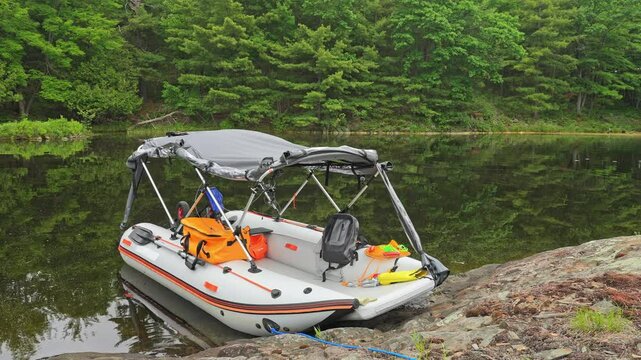 Lonely moored fishing trolling boat timelapse. Time lapse of floating and drifting boat at lake bank at wilderness lake. Anchored to small island empty boat. Inflatable motorized boat with tent.