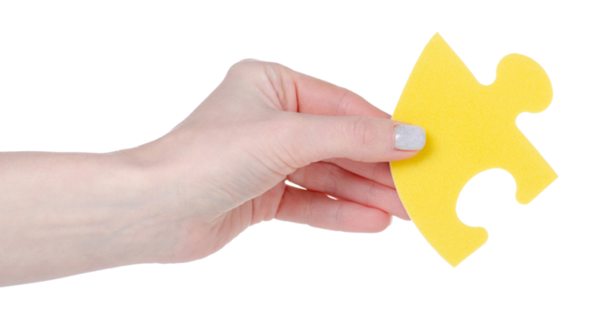 Yellow puzzle in hand isolation