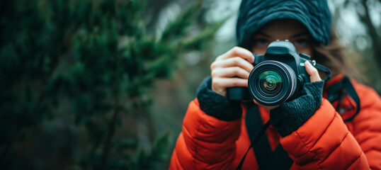 Fototapeta premium A person in a red jacket captures a photograph amidst a natural setting, embodying passion for photography and exploration.