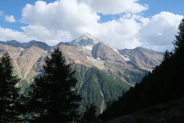 Fototapeta premium Snow capped peak of Bietschhorn as seen from the Lötschberg Panoramaweg hiking tour in Switzerland, on a sunny, partially cloudy day.