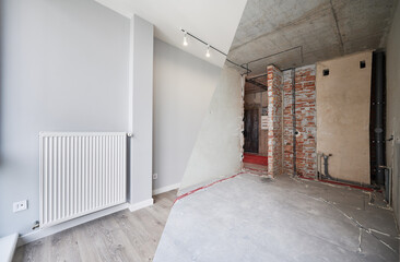 Empty living room with installed heating system before and after restoration. Comparison of old apartment and new renovated flat with parquet floor, radiator and white wall. Home renovation concept.