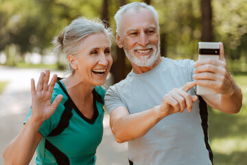 Happy senior couple video calling while taking a break in the park