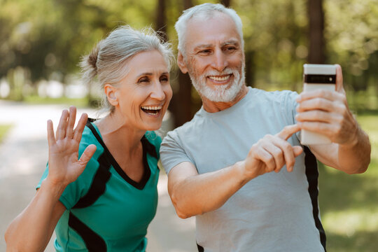 Happy senior couple video calling while taking a break in the park