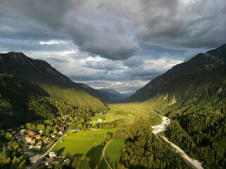 valley in Slovenia surrounded by high mountain ranges covered with dense forests through which...