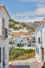 Street, mountain and travel with old city, adventure and journey with nature, Frigiliana and Andalusia. Spain, empty and buildings with architecture, outdoor and road with vacation and summer holiday