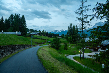 A panoramic view of the picturesque town of Cortina d'Ampezzo, nestled in the heart of the Dolomites. Majestic mountains rise in the background, offering a stunning natural backdrop.